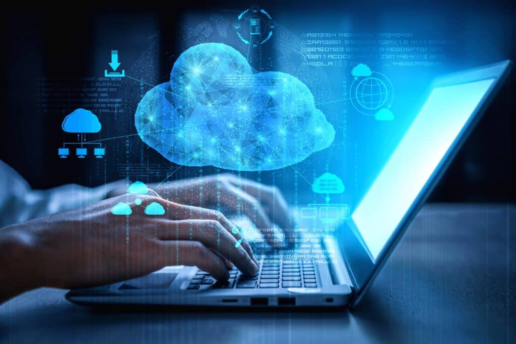 Hands typing on a laptop with digital graphics of clouds and technological icons, symbolizing cloud computing and data connectivity.